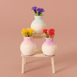 Miniature dollhouse ceramic vases with colorful flowers on a tiny two-tier wooden shelf