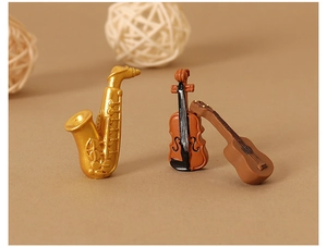 Detalle de saxofón, violín y guitarra en miniatura de resina para micro-paisajismo