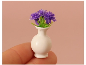 Miniature dollhouse vase with purple flowers held by hand showing micro scale detail
