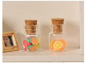 Close-up of miniature glass jars with colorful fruit slices and cork stoppers for dollhouses