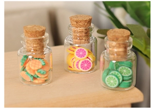 Detailed view of three miniature glass bottles with corks filled with tiny fruit slices