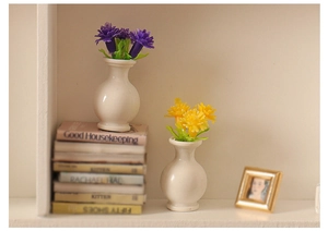 Macro shot of miniature dollhouse ceramic vases with tiny purple and yellow flowers