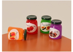 Vue détaillée de quatre mini pots de confiture de maison de poupée avec étiquettes