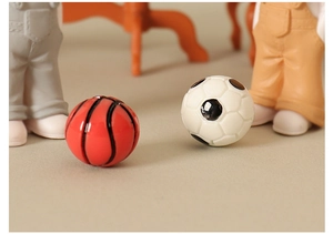 Macro shot of miniature red basketball and white soccer ball for dollhouse decoration