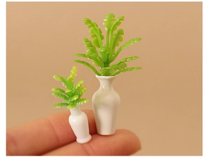 Close-up of dollhouse miniature green plants in white ceramic vases on a fingertip