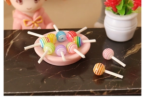 Primer plano de mini piruletas 3D de resina de colores en una bandeja rosa para manualidades