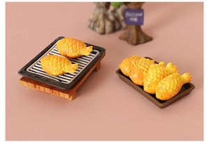 Detailed close-up of miniature dollhouse Taiyaki models on a tiny BBQ grill and tray