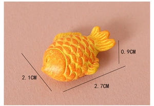 Detailed macro view of a miniature 2.7cm resin goldfish figurine for dollhouse decor