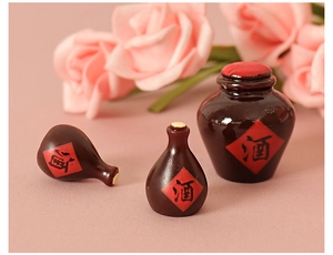 Detailed view of three miniature resin wine jugs with red labels and glossy brown finish