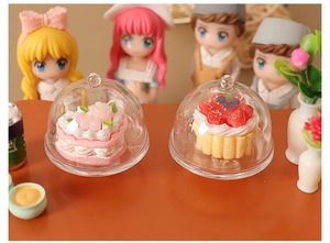Miniature dollhouse dessert set with rose cake and fruit tart under glass covers