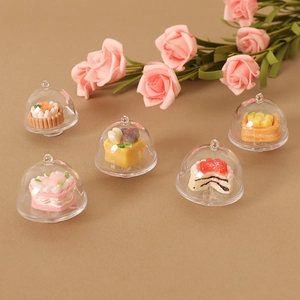 Miniature dollhouse food play set with five detailed cakes under clear dome covers