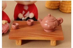 Miniature dollhouse tea set with plum blossom carving on a faux wood table
