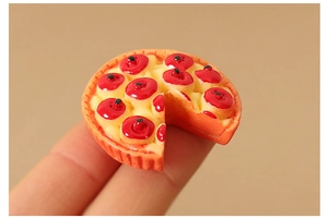 Miniature cherry tart dollhouse food model held by fingers to show small scale
