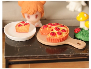 Detailed view of a miniature resin fruit tart on a tiny white plate for dollhouse decor