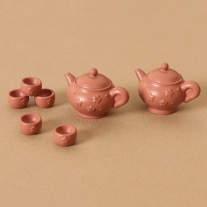 Miniature dollhouse ceramic tea set with tiny clay teapots and floral relief cups