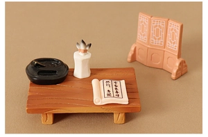 Detailed macro view of dollhouse miniature oriental study desk with ink wash pens and screen