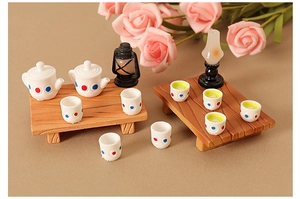 Miniature dollhouse tea set with polka dot teapots, tiny cups, and vintage oil lamp models