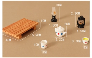 Macro view of miniature dollhouse tea set with lantern and wooden table model