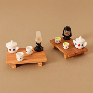 Miniature dollhouse tea set with polka dot pattern teapot and cups on wood base