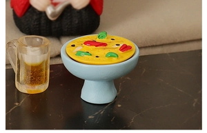 Miniature dollhouse scene with lifelike pizza model and fake beer on marble table