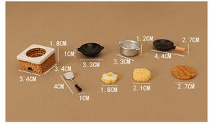 Detailed set of dollhouse kitchen miniatures with pans and stove on warm background