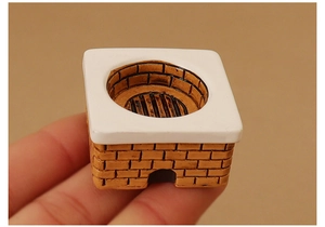 Macro view of miniature dollhouse kitchen stove with realistic red brick texture details
