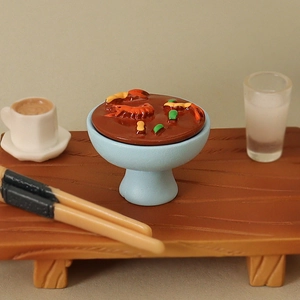 Miniature blue ceramic bowl with dollhouse shrimp soup on a rustic wooden tray