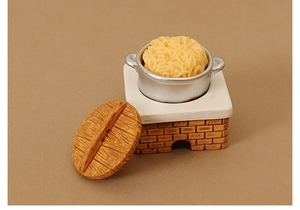 Detailed macro view of dollhouse miniature kitchen stove with tiny silver pot and noodle bowl