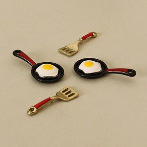 Miniature dollhouse kitchen set with tiny frying pans and golden spatulas for DIY decor
