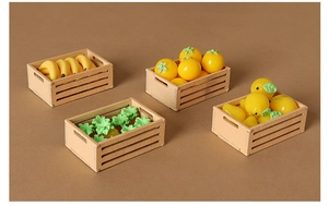Detailed macro view of four miniature dollhouse wooden crates filled with resin fruits
