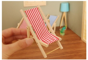 Miniature wooden folding beach chair for dollhouse showing small scale with hand