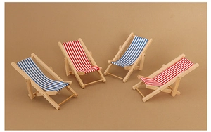 Macro detail of four miniature wooden folding beach chairs in red and blue stripes