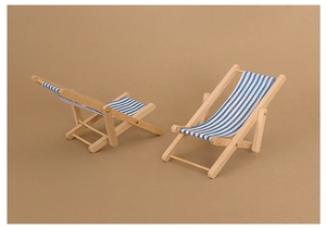 Macro detail of miniature wooden beach chairs with blue and white striped canvas fabric