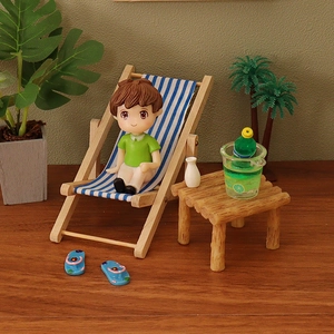 Miniature dollhouse beach set with striped folding chair, round table, and boy figurine
