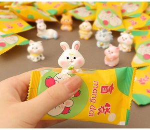 Gros plan d'une mini figurine de lapin en résine sortant d'un sac surprise jaune et vert vif