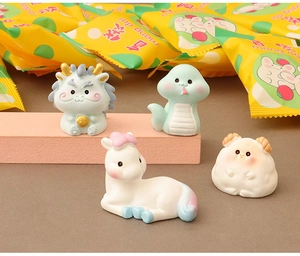 Détail de figurines d'animaux en résine et pochettes surprises jaunes pour bricolage