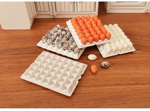 Detailed view of 1:12 dollhouse miniature egg trays and resin eggs on wooden background