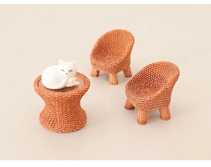 Miniature dollhouse scene with woven texture chairs and a white cat on a round table