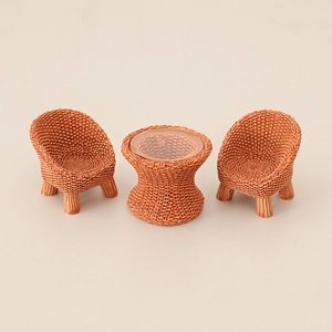 Miniature dollhouse furniture set with two caramel woven chairs and a round glass table