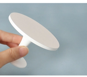 Handheld view of a miniature white wooden round pedestal table for dollhouse decor
