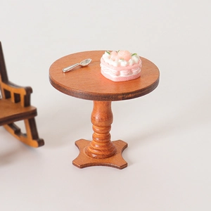 Miniature round wood dollhouse table with pink heart cake and tiny silver spoon
