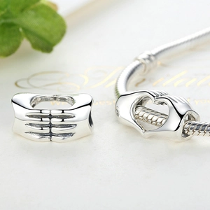 Ciondolo a cuore in argento lucido con due mani che formano un cuore su catena snake