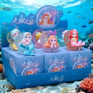 Close-up of cute mermaid figurines in glowing shell bases for ocean themed decor