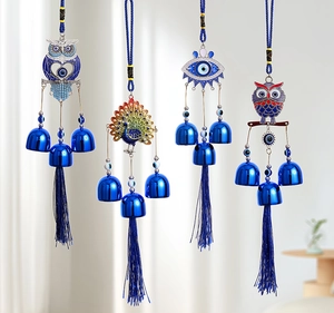 Detailed close-up of blue evil eye charms featuring owl and peacock with silk tassels