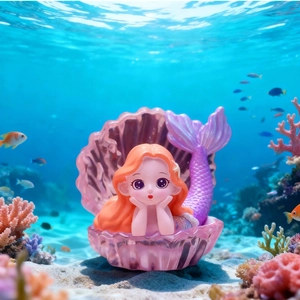 Mermaid figurine with orange hair and purple tail inside a glowing seashell base