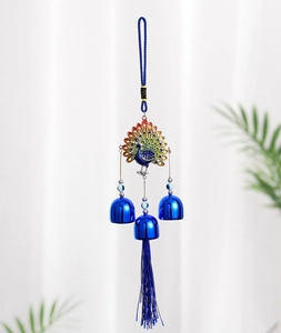 Detail of colorful metal peacock wind chime with blue evil eye beads and decorative tassels