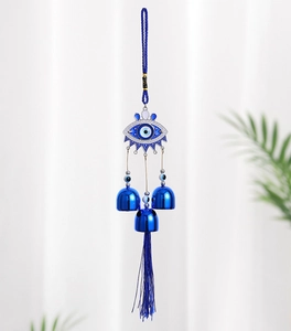Detail showing blue evil eye hanging decor with metallic bells and long silk tassels