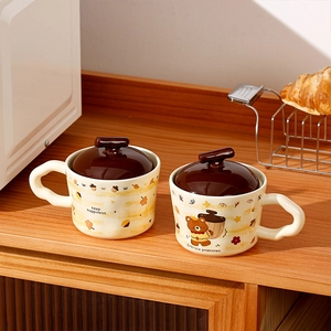 Detail of cream ceramic bear mug with unique wavy handle and forest theme pattern