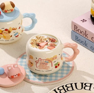 Detail of ceramic mug featuring cute cartoon bear and cloud handle with rabbit lid