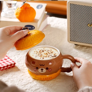 Close-up of cute cartoon bear ceramic mug with citrus lid and Good Lucky text design